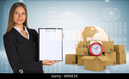 Businesswoman holding paper holder. Earth, alarm clock, cardboard boxes as backdrop Stock Photo