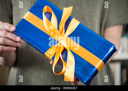 gift box in woman hands over library background Stock Photo