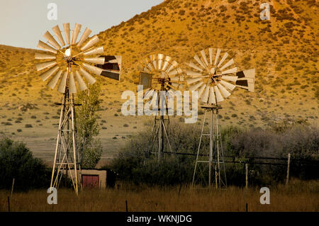 Trio of windpumps at sunset in the Southern Free State Province of South African Stock Photo