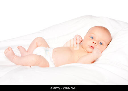 Cute baby infant laying on white pillow wearing diaper. Stock Photo