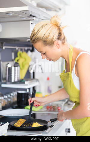 Young Mother Cooking at Home. Stock Photo
