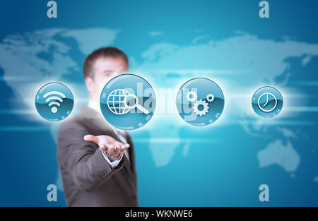 Business man hold blue application icons in hand. World map as backdrop Stock Photo