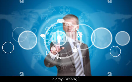 Businessman in suit pointing her finger at cloud icons. World map as backdrop Stock Photo
