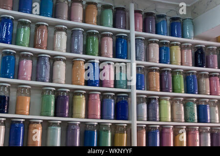 Shelving filled with rows of glass jars of colorful pigments in a apothecary or pharmacy in Marrakech, Morocco specialising in natural organic product Stock Photo