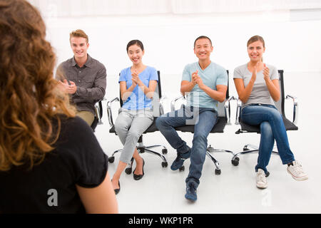 Executives sitting in seminar applauding Stock Photo