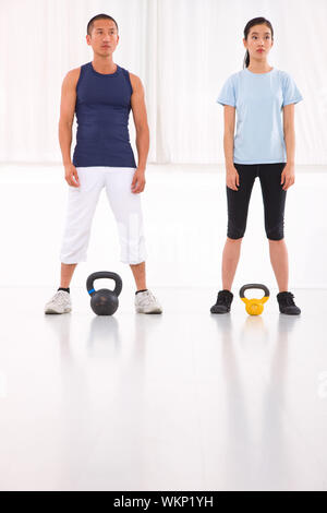 Asian man and woman doing kettle bell crossfit exercise Stock Photo