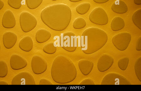 Background of Golden Sand Colored Droplet Shaped Stone on Cement Wall closeup Stock Photo