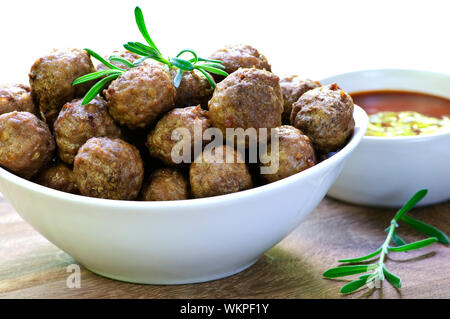 Fresh hot meatball appetizers served in white bowl with dipping sauce Stock Photo