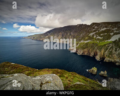 View from the cliffs of Slieve League, Co. Donegal across a small bay out to the Atlantic Ocean with the famous Giant's Chair and Table in the foregro Stock Photo