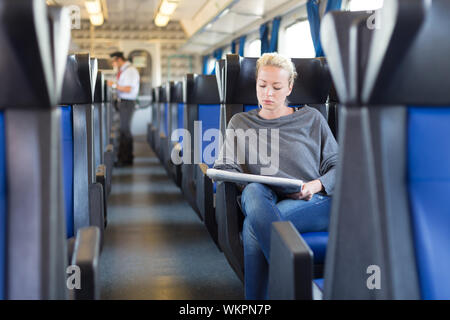 Young woman traveling by train, train conductor Stock Photo