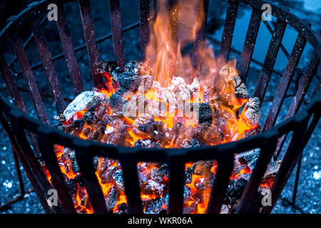 Hot burning fire coals in a metal fire basket Stock Photo
