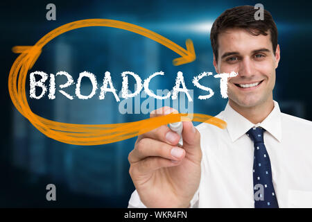Businessman writing the word broadcast against shiny cityscape on black background Stock Photo