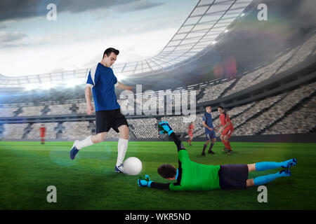 Composite image of football match in progress in large football stadium with lights Stock Photo