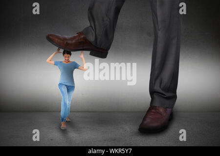 Composite image of businessman stepping on girl on grey background Stock Photo