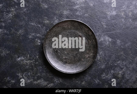 Empty black plate over dark stone background with free space. Top view, flat lay Stock Photo