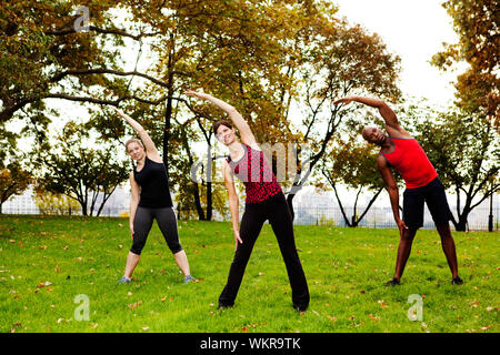 A group of people stretching in a park Stock Photo
