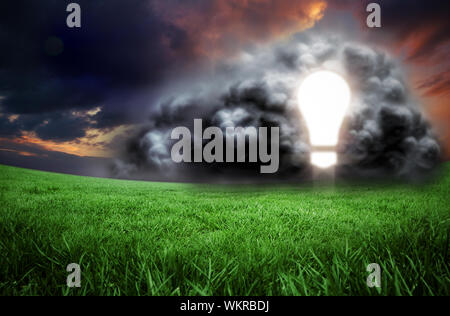 Composite image of light bulb in cloud against green field under orange sky Stock Photo