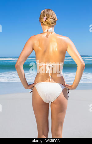 Fit woman in white bikini on the beach rear view on a sunny day Stock Photo