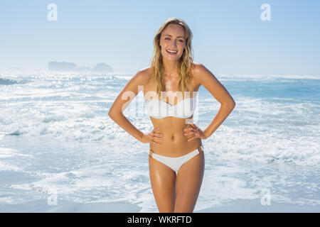 Gorgeous blonde in white bikini standing by the sea on a sunny day Stock Photo