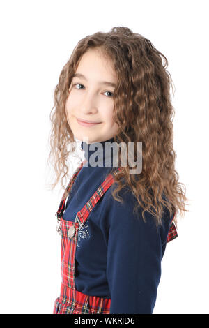 Portrait of adorable smiling schoolgirl with curl hair standing isolated on a white background. High resolution photo. Full depth of field. Stock Photo