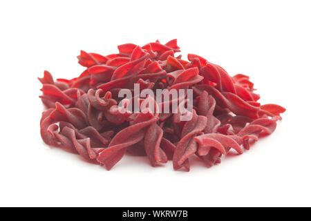 Uncooked colorful pasta with beetroot flavor isolated on white background. Stock Photo