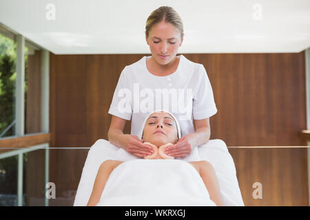 Peaceful brunette getting facial from beauty therapist in the health spa Stock Photo
