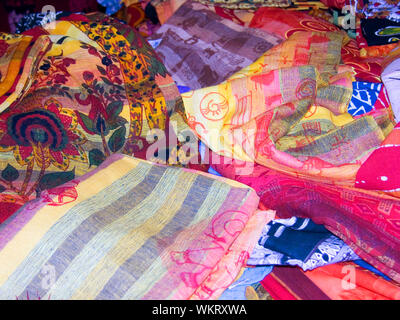 Brightly coloured fabrics on a street market stall, Rue Gambetta, Poitiers, Vienne, Nouvelle-Aquitaine, France Stock Photo