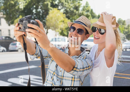 Young hip couple taking a selfie on a sunny day in the city Stock Photo