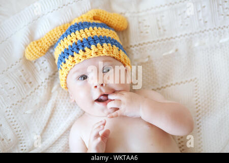 Portrait of a cute 4 months baby wearing crochet knit hat, top view point Stock Photo