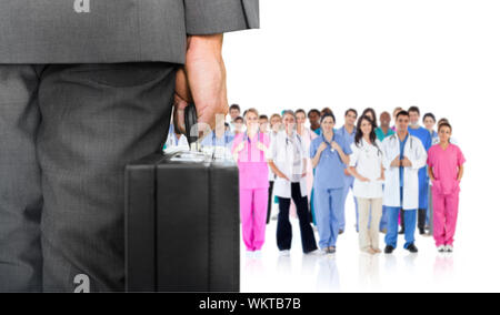 Composite image of businessman holding briefcase against group of workers Stock Photo