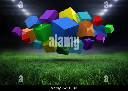 3d colourful cubes floating in a cluster against football pitch with bright lights Stock Photo