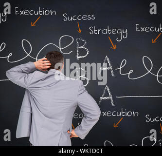 Thinking businessman against blackboard with business buzzwords Stock Photo