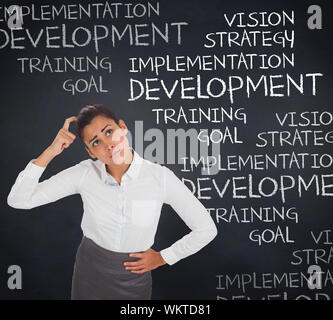 Worried businesswoman against blackboard with business buzzwords Stock Photo
