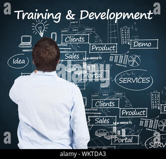 Businessman against blue chalkboard with business buzzwords Stock Photo
