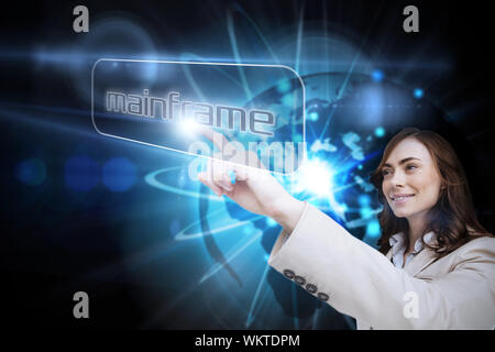 Businesswoman pointing to word mainframe against shiny sphere on black background Stock Photo