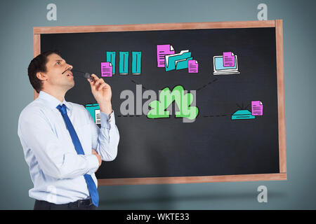 Thinking businessman biting glasses against cloud computing doodle on board Stock Photo
