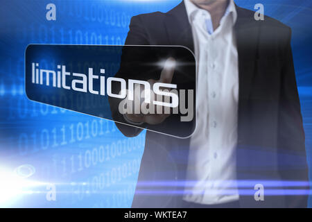 Businessman pointing to word limitations against futuristic shiny binary code Stock Photo