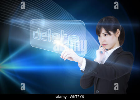 Businesswoman pointing to word delete against shiny lines on black background Stock Photo