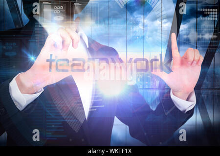 Businesswoman presenting the word teamwork against room with large window looking on city Stock Photo