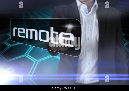 Businessman pointing to word remote against black background with shiny hexagons Stock Photo