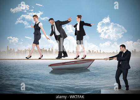 Young businessman pulling a tightrope for business people against small boat in the sea with city on horizon Stock Photo