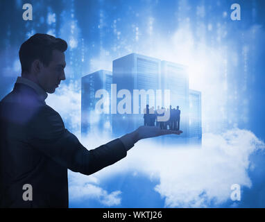Business team looking at camera held by giant businessman against data servers resting on clouds in blue Stock Photo