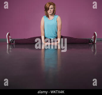 Pretty break dancer doing the splits in the dance studio Stock Photo