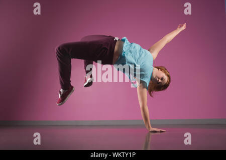 Pretty break dancer doing a handstand in the dance studio Stock Photo