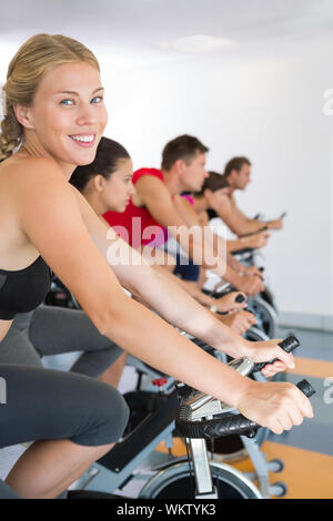 Man smiling at camera during spin class Stock Photo - Alamy