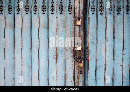 Close Up View of an Old Metal Shop Door with Locks Stock Photo