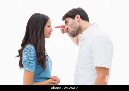 Angry man shouting at upset girlfriend on white background Stock Photo