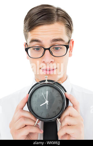 Geeky businessman holding alarm clock on white background Stock Photo