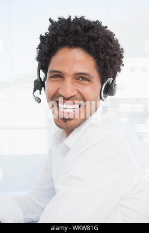 Happy businessman working at his desk wearing headset in his office Stock Photo