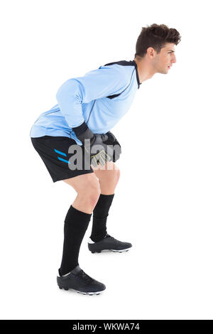 Goalkeeper in blue ready to save on white background Stock Photo